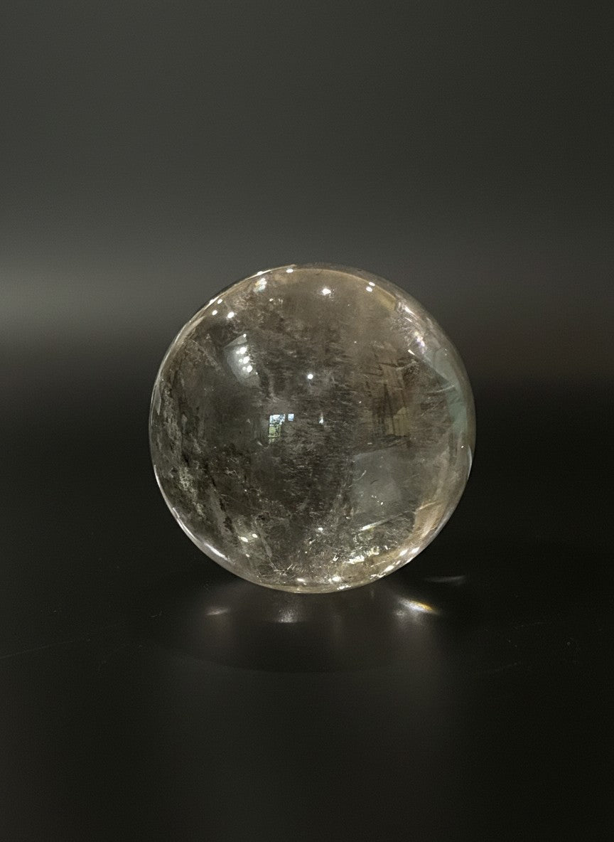 Zebra Industries, LLC collector-grade polished garden quartz sphere with natural inclusions on a black background.