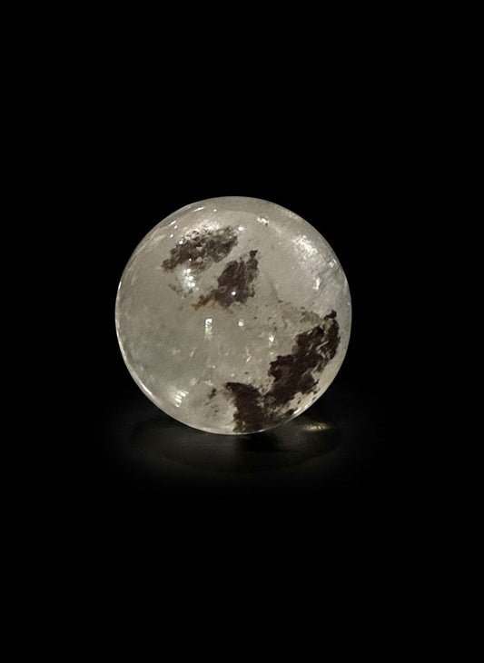 Zebra Industries, LLC collector-grade polished garden quartz sphere with natural inclusions on a black background.
