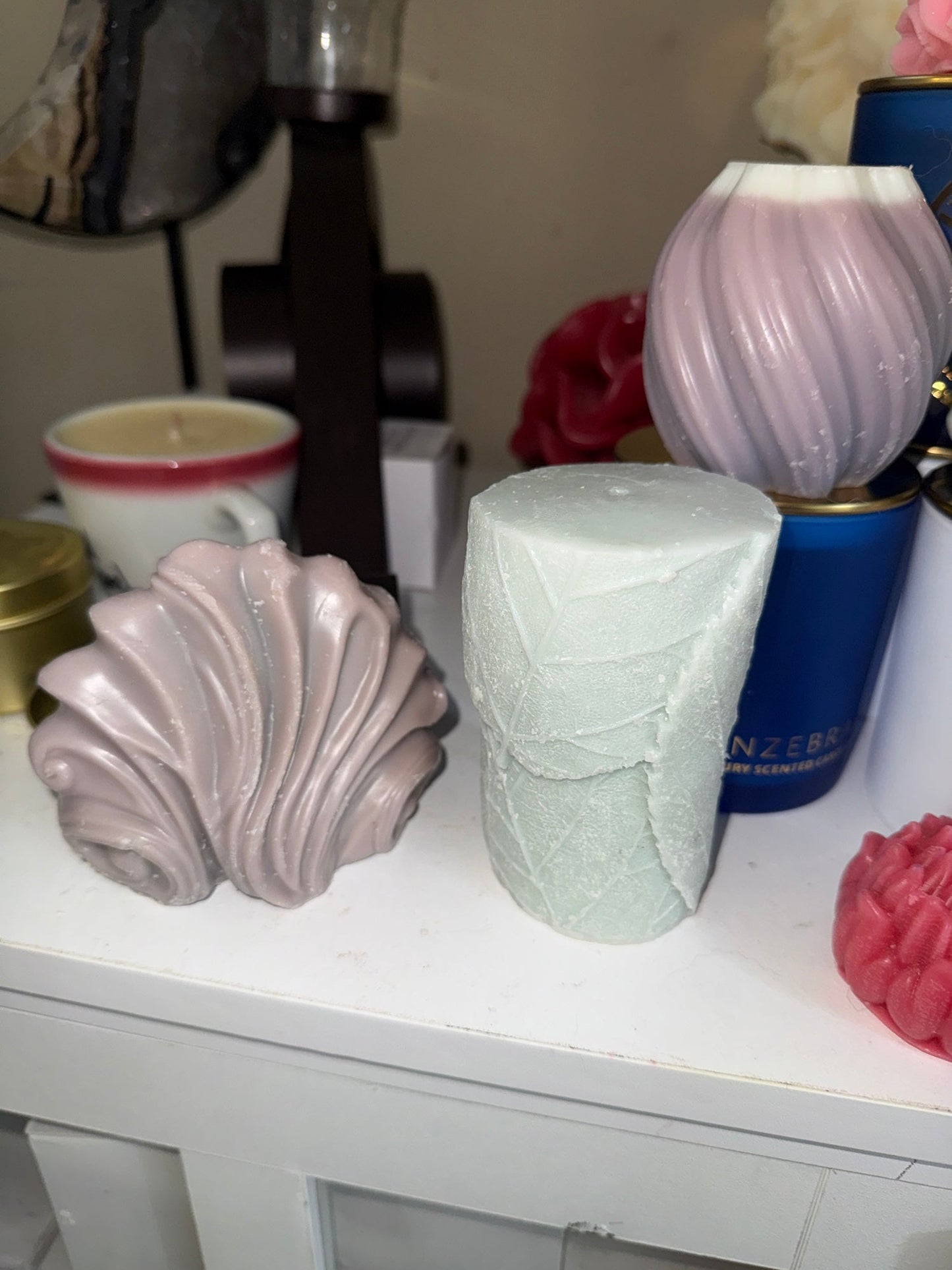 EnZebra decorative sculptural candles — shell, white lattice pillar, lavender orb