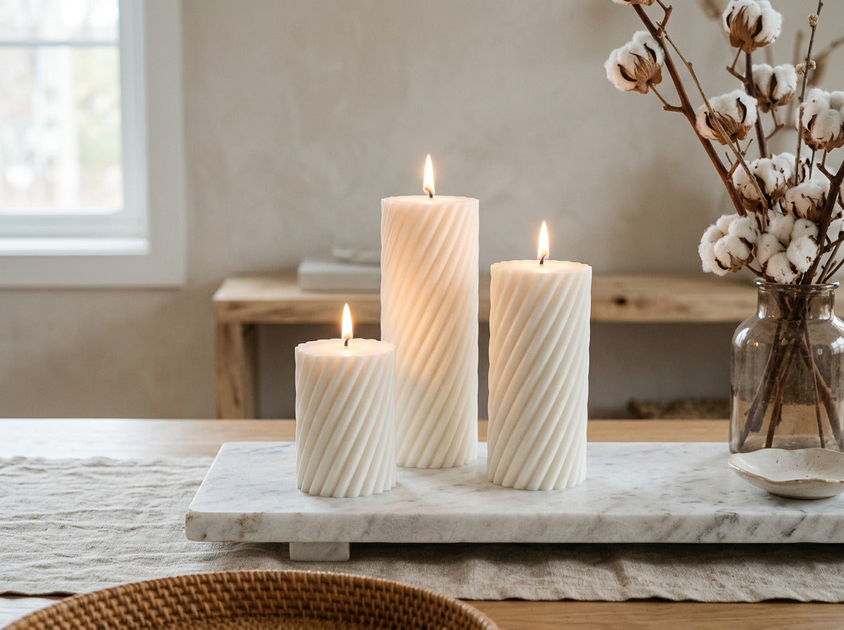 EnZebra White Swirl Pillar candles lit on shelf — lifestyle