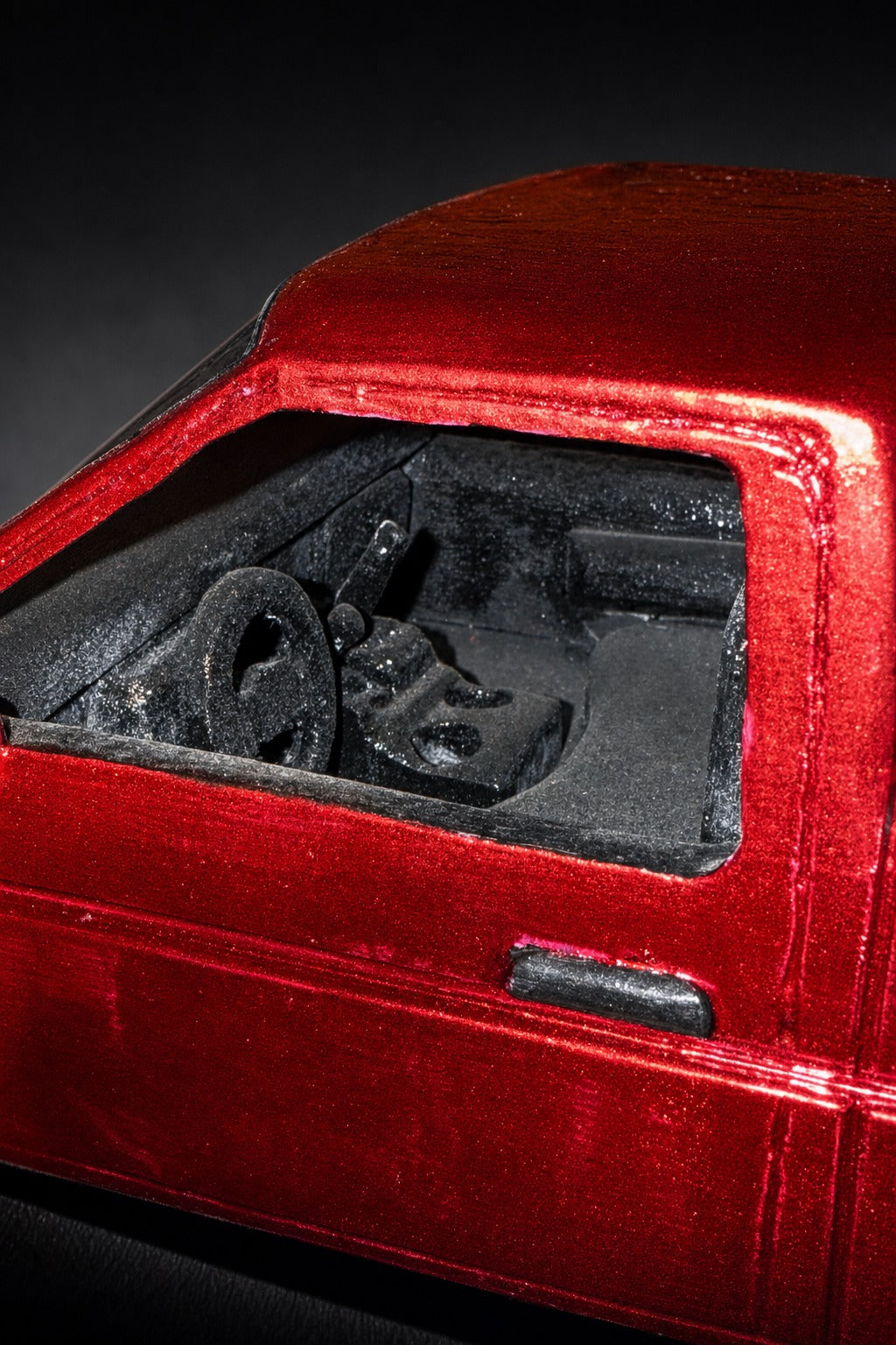 Garland Workshop Dominator — cab window macro, metallic red wood grain, steering wheel