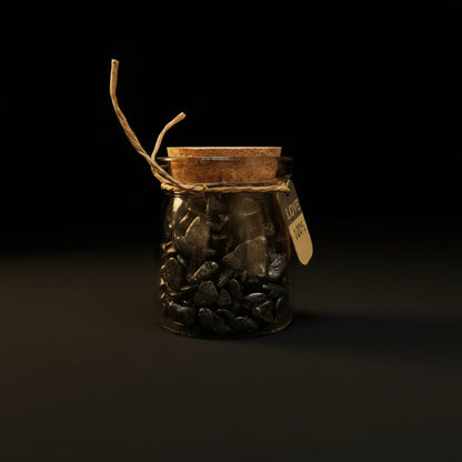 Zebra Industries, LLC glass jar filled with smooth black tumbled mineral chips, sealed with a cork and twine tag.