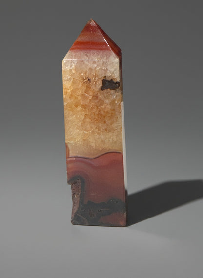 Zebra Industries, LLC polished carnelian agate geode tower with a sparkling druzy quartz interior and banded patterns.