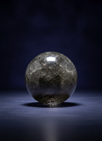 Zebra Industries, LLC garden quartz sphere with dark chlorite inclusions and phantom formations on a dark background.