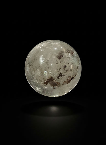 Zebra Industries, LLC garden quartz sphere with hematite inclusions and iron oxide patterns on a black background.