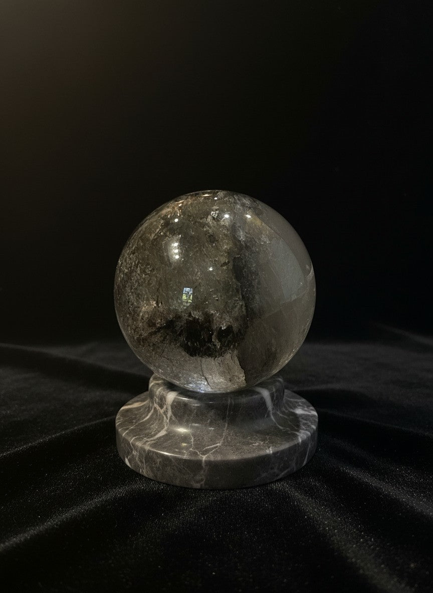 Zebra Industries, LLC collector grade garden quartz sphere with green mineral inclusions on a grey marble stand.