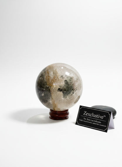 Zebra Industries, LLC polished garden quartz crystal sphere with natural inclusions on a wooden stand.