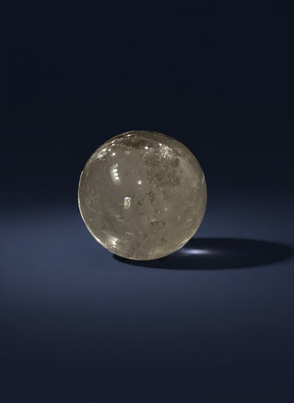 Zebra Industries, LLC polished garden quartz sphere with intricate natural inclusions on a dark blue background