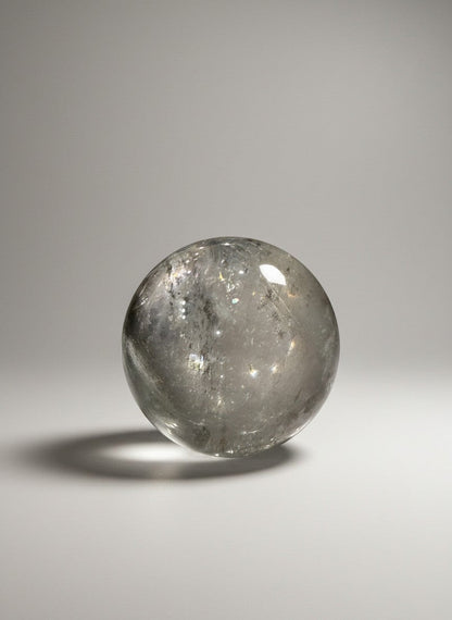 Zebra Industries, LLC collector grade garden quartz crystal sphere with clear inclusions on a white background.