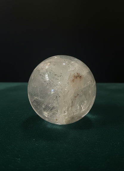 Zebra Industries, LLC collector grade Garden Quartz crystal sphere with natural mineral inclusions on green surface.
