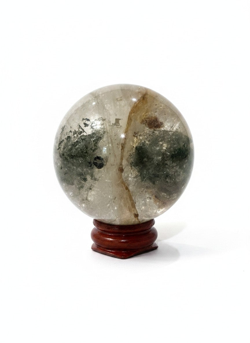 Zebra Industries, LLC garden quartz crystal sphere with natural green inclusions on a polished wooden display stand.