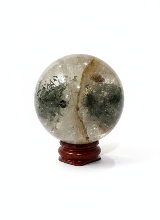 Zebra Industries, LLC garden quartz crystal sphere with natural green inclusions on a polished wooden display stand.