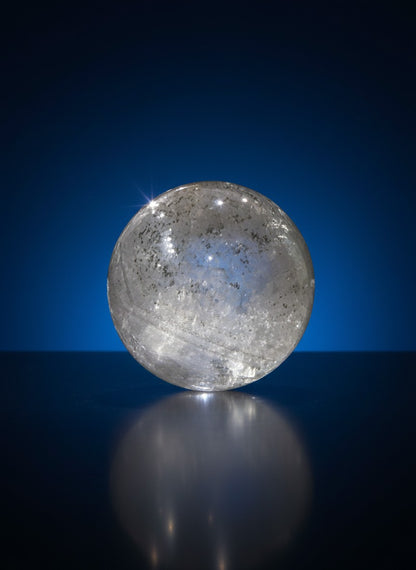 Zebra Industries, LLC collector grade Garden Quartz crystal sphere with natural mineral inclusions on a dark surface.
