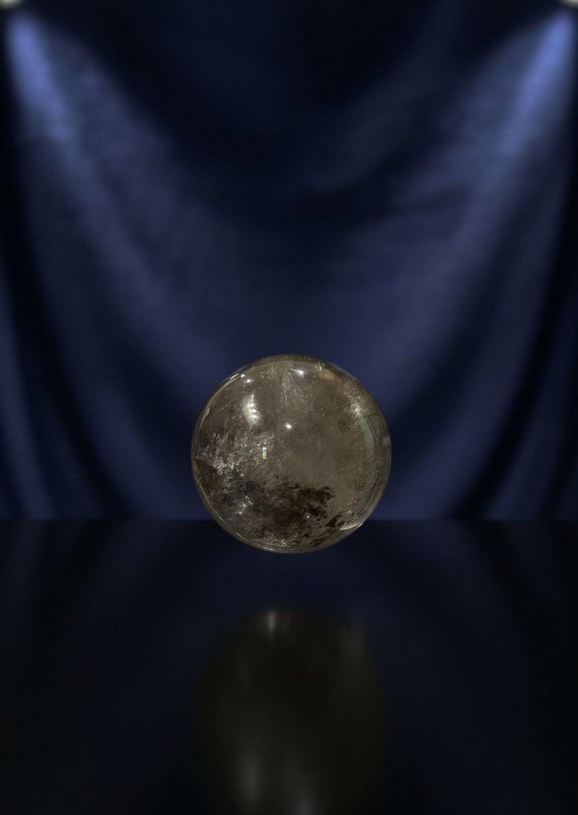 Zebra Industries, LLC collector grade polished garden quartz sphere with natural inclusions on a dark reflective base.