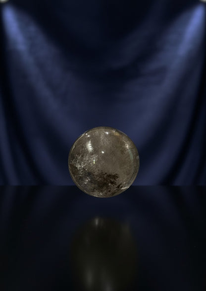 Zebra Industries, LLC collector grade polished garden quartz sphere with natural inclusions on a dark reflective base.