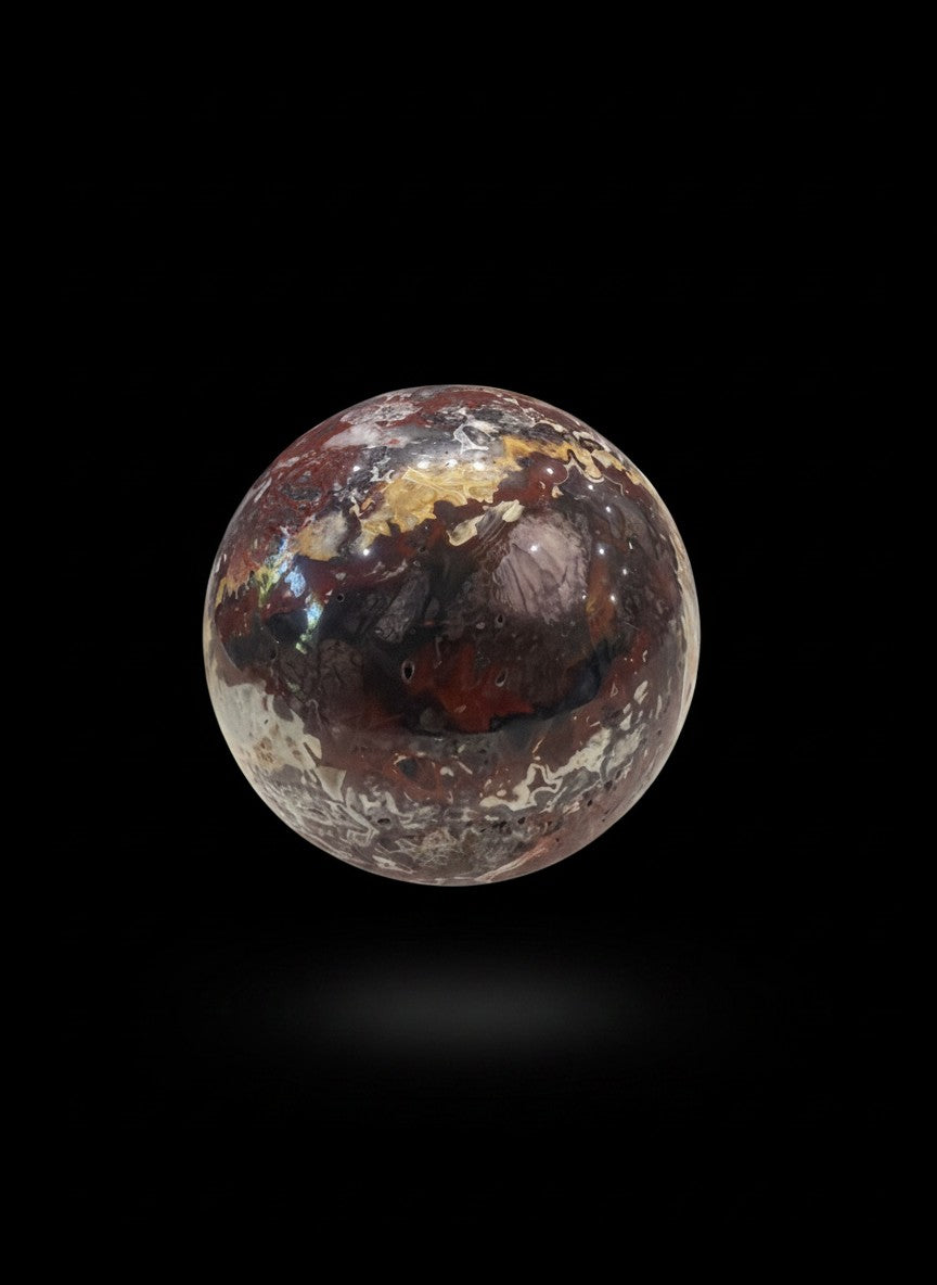 Zebra Industries, LLC Laguna Lace agate sphere with intricate patterns and a natural druzy cavity on black background.