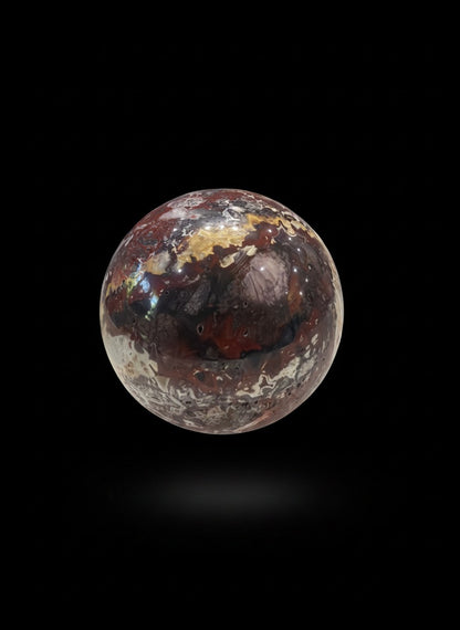 Zebra Industries, LLC Laguna Lace agate sphere with intricate patterns and a natural druzy cavity on black background.