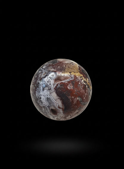 Zebra Industries, LLC Laguna Lace agate sphere with intricate patterns and a natural druzy cavity on black background.