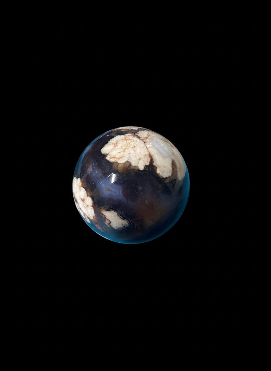 Zebra Industries, LLC polished agate sphere with deep blue chalcedony and organic white druzy inclusions on black background