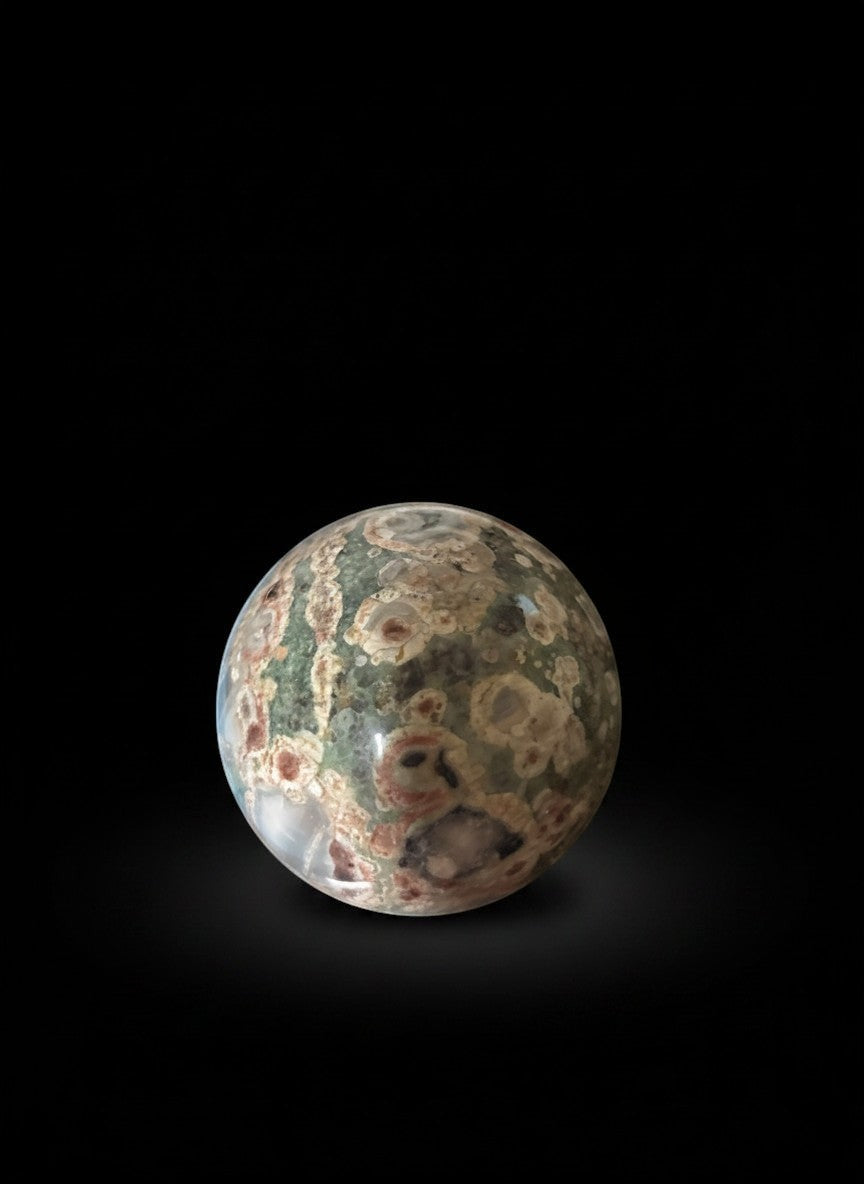 Zebra Industries, LLC polished orbicular rhyolite jasper sphere with intricate multi-colored natural stone patterns.
