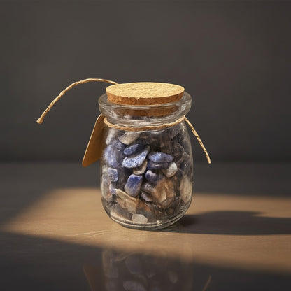 Zebra Industries, LLC glass jar filled with tumbled mineral chips including red jasper, sodalite, and quartz crystals.